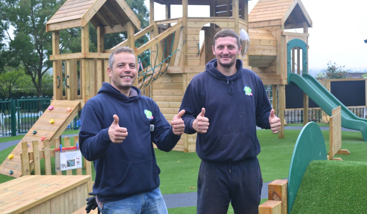 team (5) Playground Equipment installers in Kent with thumbs up in front of timber climbing frame and tower